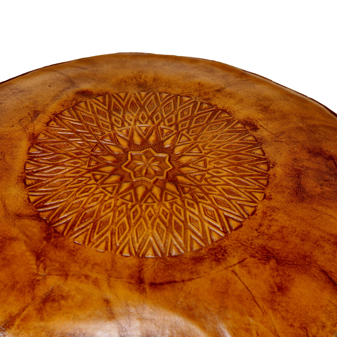 Detailansicht der geprägten Oberseite eines Leder Poufs in warmem Braun mit feinem orientalischem Muster und natürlicher Lederstruktur.