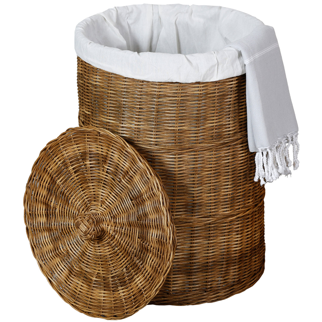 Panier à linge en rotin brun foncé avec sac clair, linge blanc à franges et couvercle rond retiré