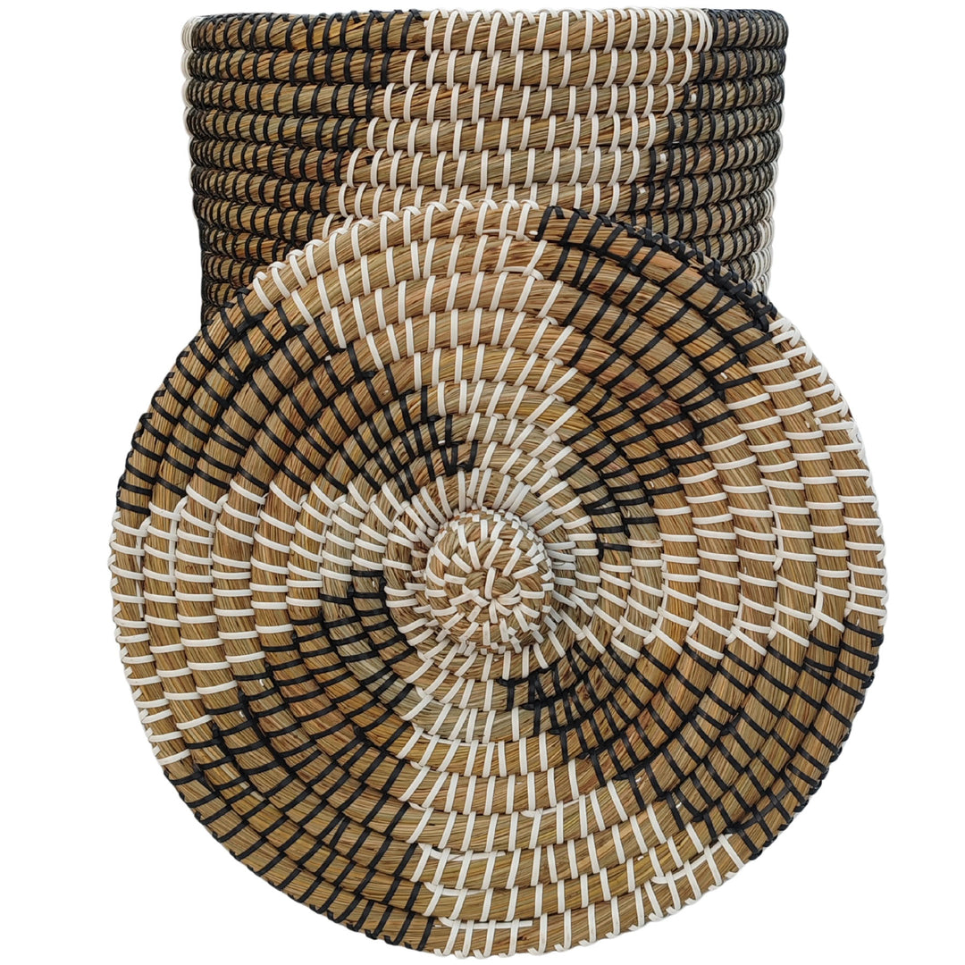 Panier en jonc de mer d'une contenance d'environ 40 litres ; devant, gros plan sur le couvercle à motifs orné d'un pommeau tressé.