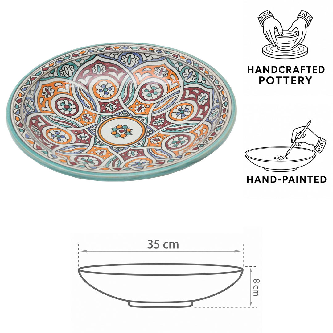 Bol en céramique marocaine peint à la main, orné d'un motif circulaire dans les tons turquoise, orange et bordeaux, d'un diamètre de 35 cm et d'une hauteur de 8 cm