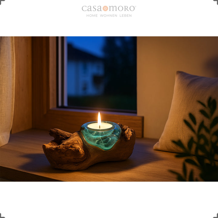 Teelichthalter aus Glas und Wurzelholz auf einer Fensterbank, sein warmes Licht bringt am Abend eine sanfte, beruhigende Atmosphäre.