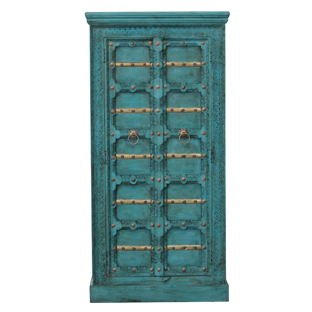 Vue de face de l’armoire turquoise en manguier massif, avec motifs sculptés et éléments décoratifs dorés.