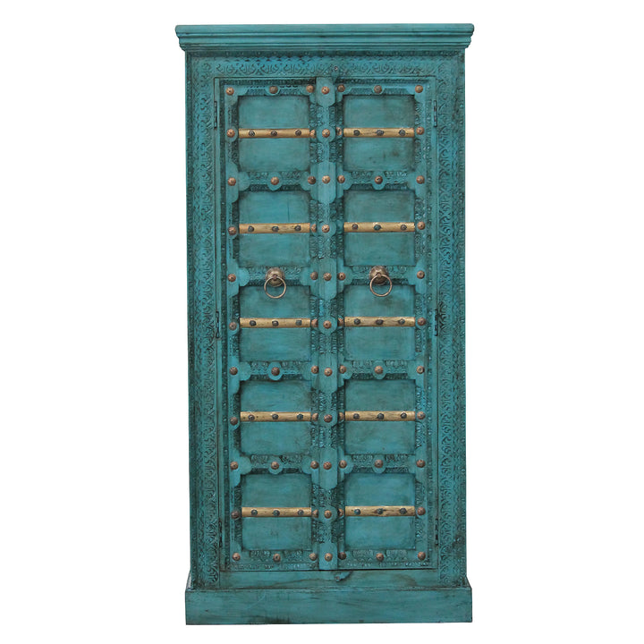 Vue de face de l’armoire turquoise en manguier massif, avec motifs sculptés et éléments décoratifs dorés.