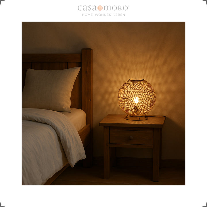 Runde Rattan Nachttischlampe auf Holztisch neben Bett, warmes Licht und gemütliche Atmosphäre