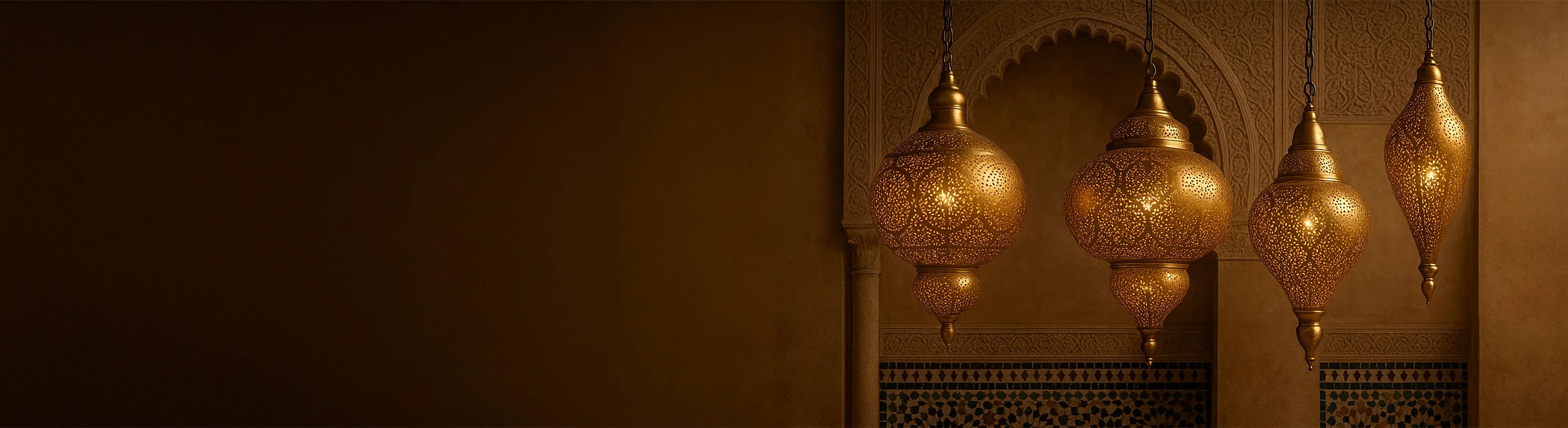 Plafonniers orientaux en laiton – Des plafonniers orientaux en laiton sont suspendus devant des arches ornées et des murs en mosaïque dans un intérieur marocain.