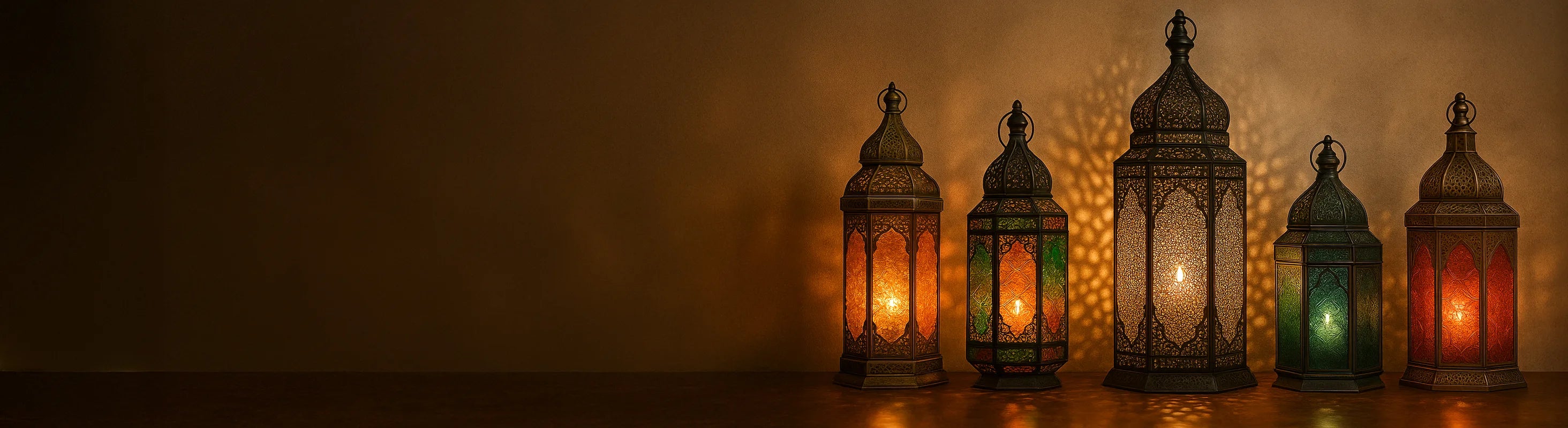 Lanternes orientales – Orientalische Laternen aus Glas und Metall auf einem Steinboden vor marokkanischem Hintergrund und spenden warmes, stimmungsvolles Licht.