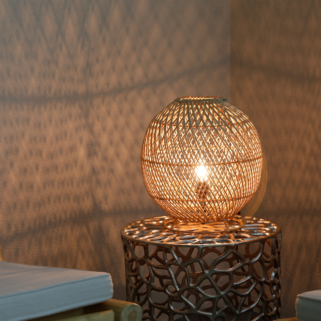 Runde Rattanlampe auf Beistelltisch im Wohnzimmer mit feinem Lichtmuster an der Wand