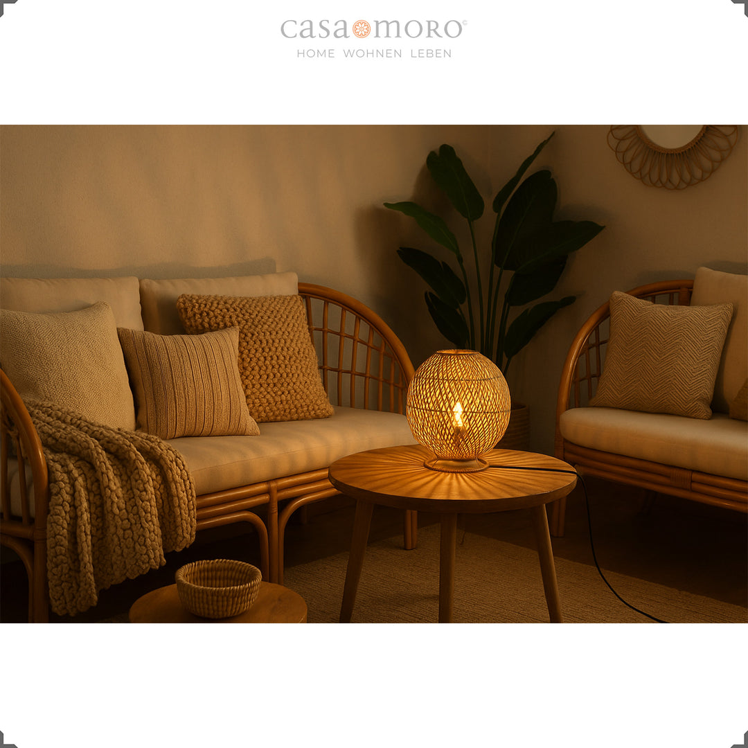 Runde Rattanlampe auf Couchtisch zwischen Sitzmöbeln, warmes Licht und gemütliches Ambiente