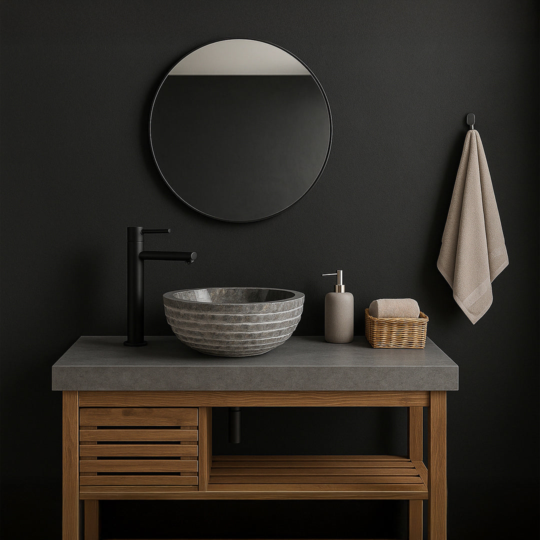 Lavabo en pierre grise comme lavabo à poser sur le meuble sous-vasque, salle de bains moderne avec murs sombres, miroir et accessoires noirs