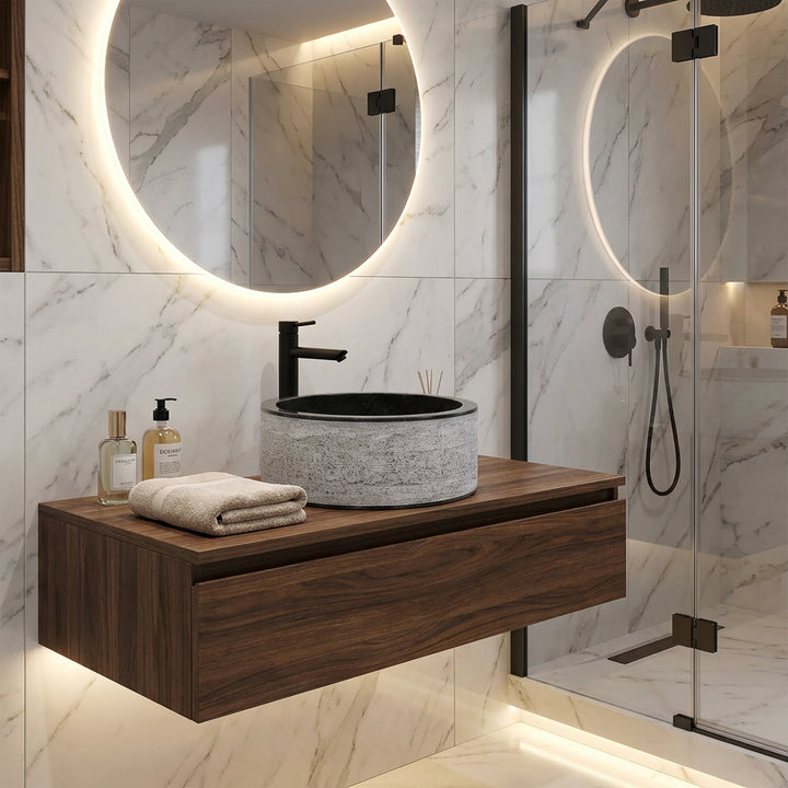 Lavabo rond en pierre sur une console flottante en bois, combiné de façon moderne avec des robinetteries noires dans une élégante salle de bain design.