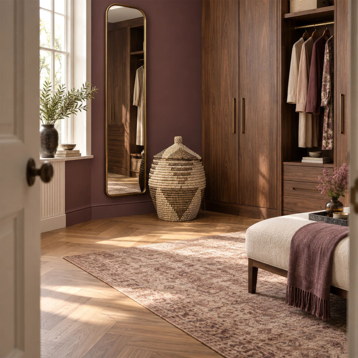 Grand panier en jonc de mer, couvercle conique, tressage brun naturel, blanc et noir, près d’un miroir dans le dressing.