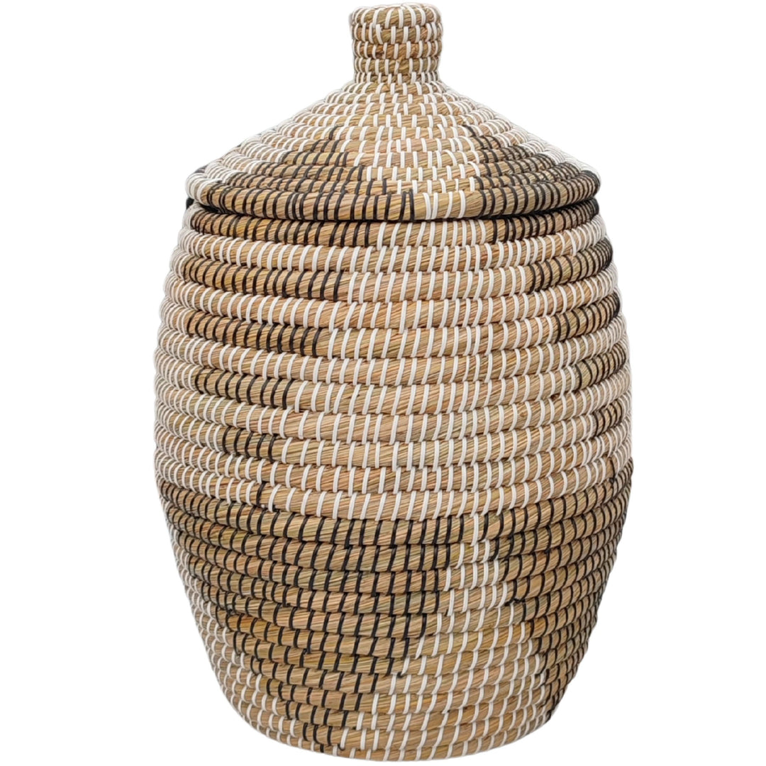 Panier bombé en jonc de mer vu de face, couvercle conique à bouton tressé, brun naturel aux motifs blancs et noirs.