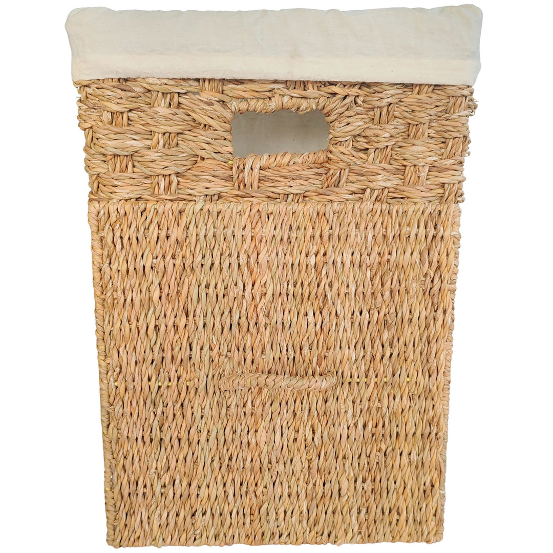 Panier à linge carré en jonc de mer, doté d'un insert en tissu clair et d'un couvercle amovible qui repose contre l'avant du panier.