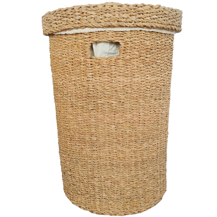 Panier à linge rond en jonc de mer d'une capacité de 75 litres, muni d'un couvercle fermé, d'une poignée et d'un insert en tissu clair.